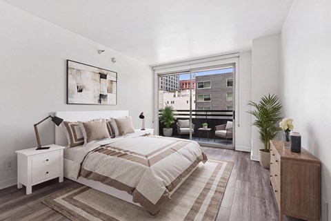 A bedroom with a large bed and a view of a cityscape through a window.
